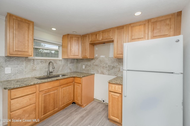 kitchen featuring white refrigerator, sink, decorative backsplash, light wood-type flooring, and ornamental molding