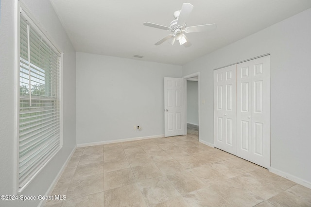 unfurnished bedroom with ceiling fan, a closet, and light tile patterned flooring