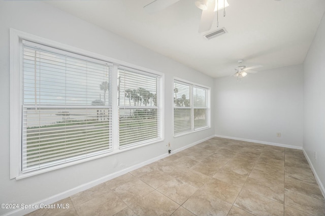 unfurnished room with light tile patterned floors and ceiling fan