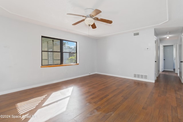 spare room with dark hardwood / wood-style flooring and ceiling fan