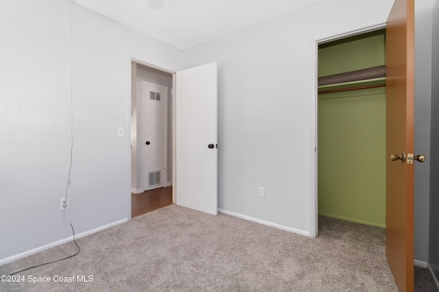 unfurnished bedroom with a closet and light carpet