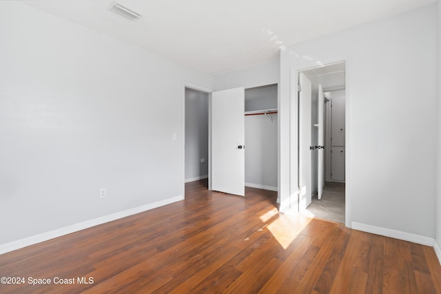 unfurnished bedroom featuring dark hardwood / wood-style floors and a closet