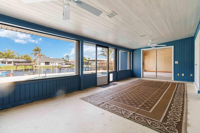 unfurnished sunroom featuring wood ceiling and ceiling fan