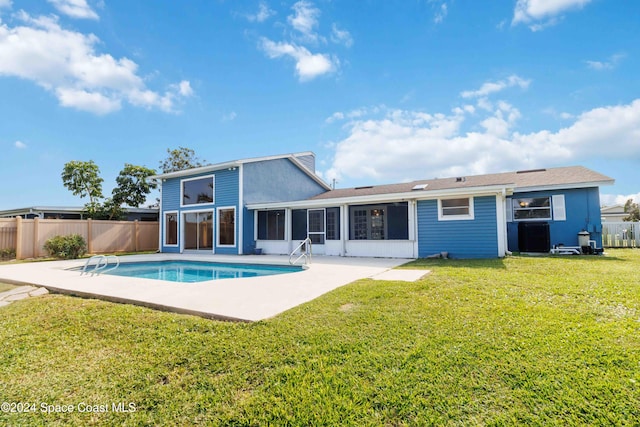 back of property with a fenced in pool, a sunroom, a yard, and a patio