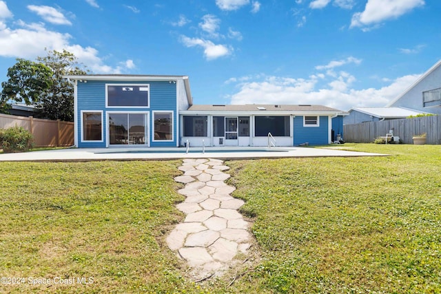 back of property with a yard and a patio