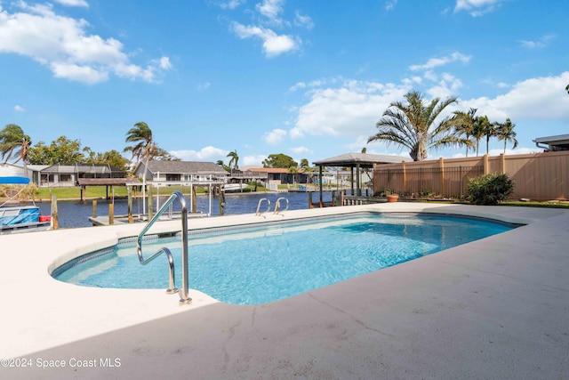 view of pool featuring a water view and a patio area