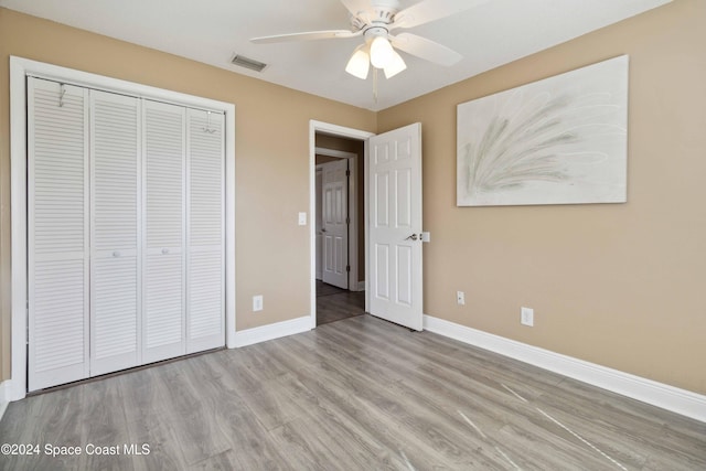 unfurnished bedroom featuring ceiling fan, a closet, and light hardwood / wood-style flooring