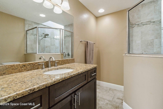 bathroom featuring a shower with door, vanity, and tile patterned flooring