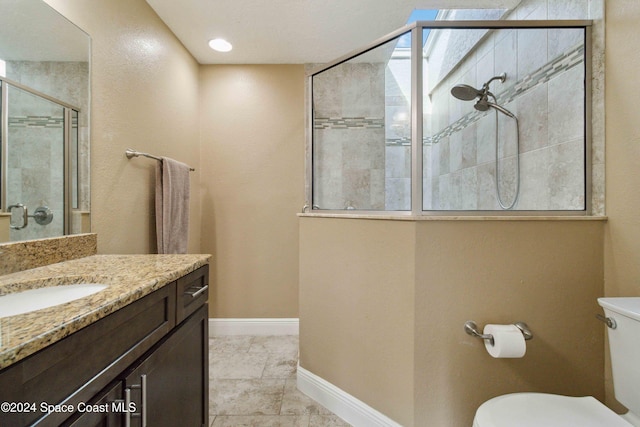 bathroom featuring walk in shower, vanity, tile patterned floors, and toilet