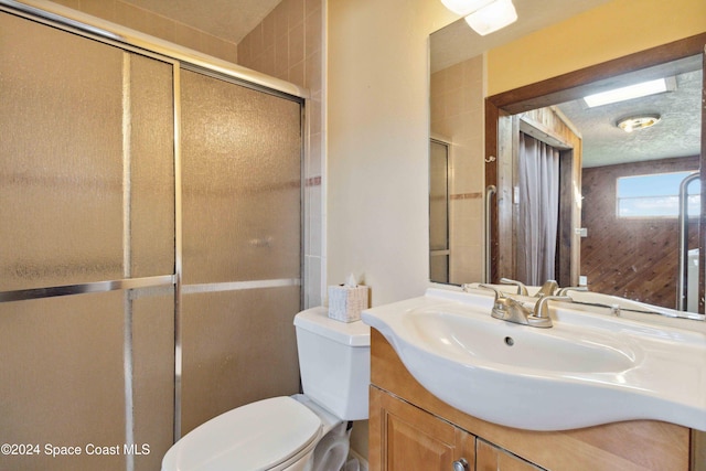 bathroom with walk in shower, vanity, toilet, and a textured ceiling