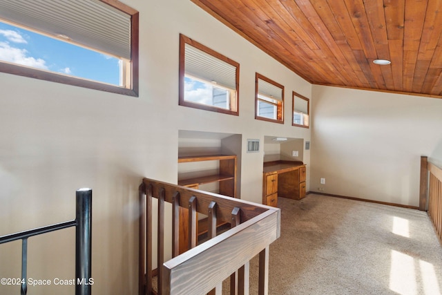 stairway featuring wooden ceiling, a high ceiling, and carpet flooring