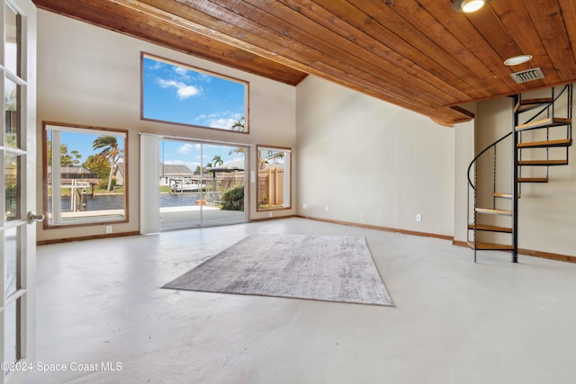 unfurnished living room featuring a water view, wood ceiling, and concrete floors