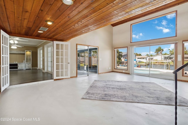 interior space featuring a healthy amount of sunlight, ceiling fan, wood ceiling, and concrete floors