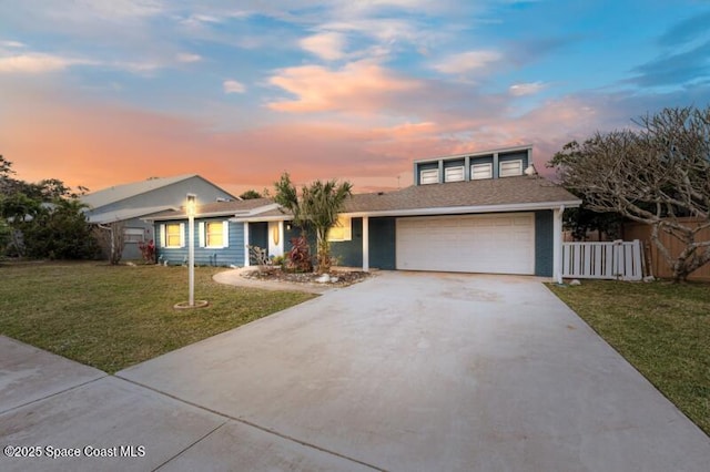 view of front of house featuring a garage and a lawn