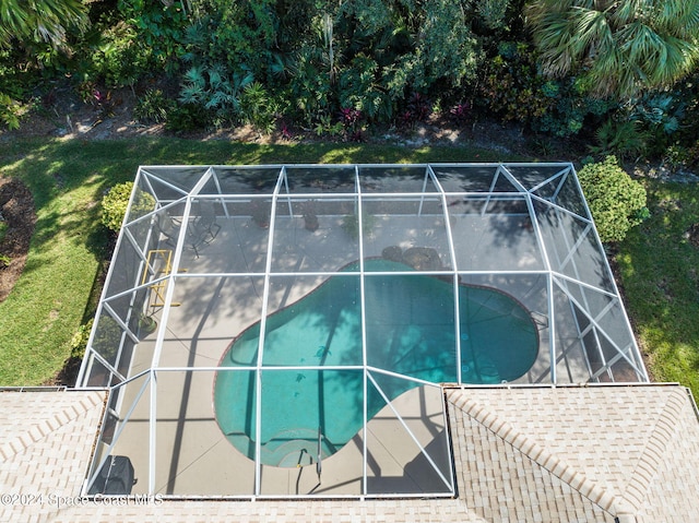 view of swimming pool with a patio and glass enclosure