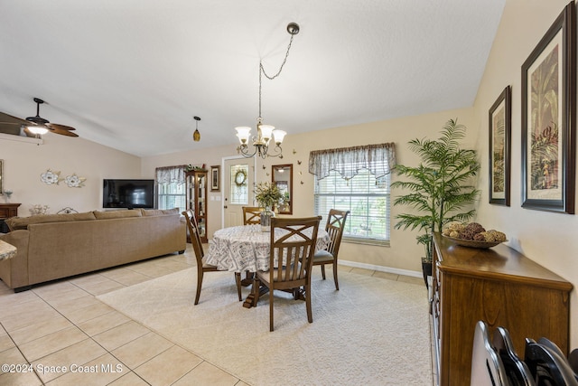 tiled dining room featuring ceiling fan with notable chandelier and vaulted ceiling