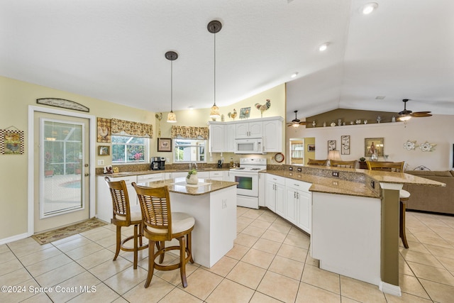 kitchen featuring kitchen peninsula, a breakfast bar area, white appliances, lofted ceiling, and white cabinets