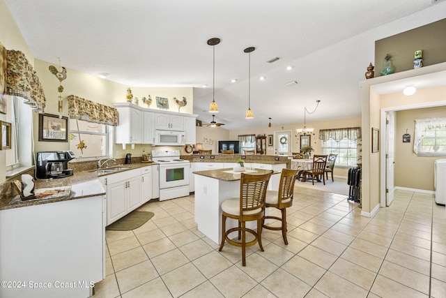 kitchen featuring kitchen peninsula, decorative light fixtures, white appliances, a kitchen island, and white cabinets