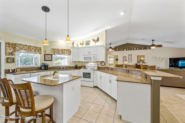 kitchen with kitchen peninsula, a kitchen bar, decorative light fixtures, white appliances, and lofted ceiling