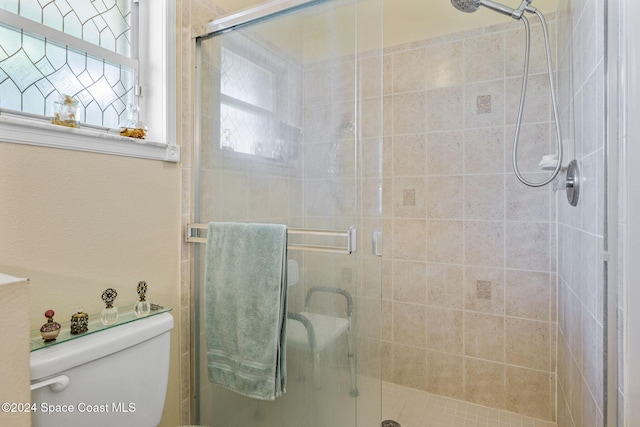 bathroom with toilet and a shower with shower door