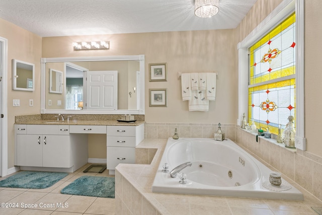 bathroom featuring vanity, a textured ceiling, tile patterned floors, and tiled tub