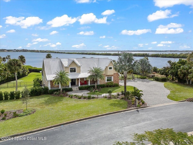 view of front of house featuring a front yard, a water view, and a porch