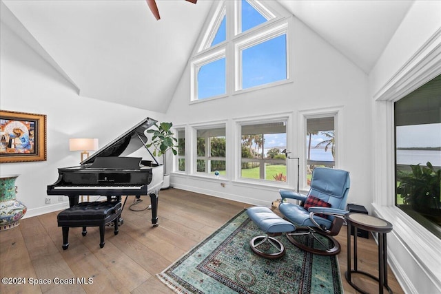 sitting room featuring ceiling fan, high vaulted ceiling, and wood-type flooring