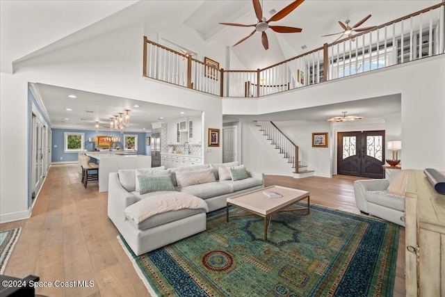 living room featuring french doors, high vaulted ceiling, and light hardwood / wood-style flooring