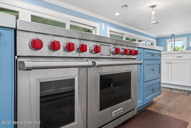 kitchen with blue cabinetry, white cabinets, dark hardwood / wood-style floors, and ornamental molding