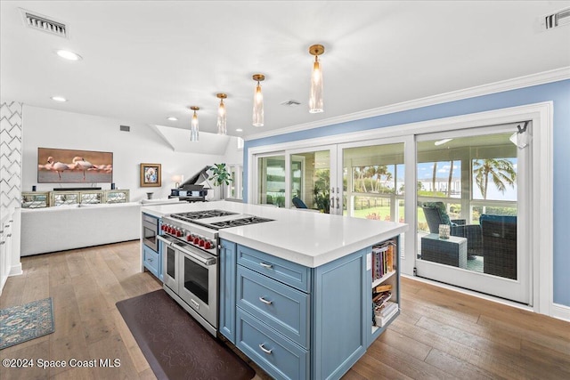 kitchen featuring crown molding, light hardwood / wood-style flooring, decorative light fixtures, and range with two ovens