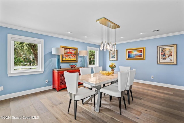 dining area featuring hardwood / wood-style floors and ornamental molding