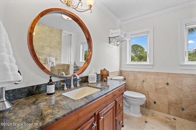 bathroom with tile patterned floors, vanity, toilet, tile walls, and crown molding