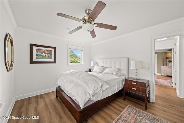 bedroom with dark hardwood / wood-style flooring, ceiling fan, and ornamental molding