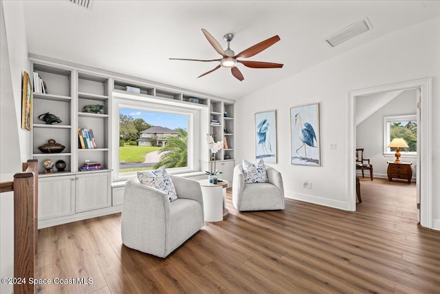 living area with vaulted ceiling, dark wood-type flooring, and plenty of natural light