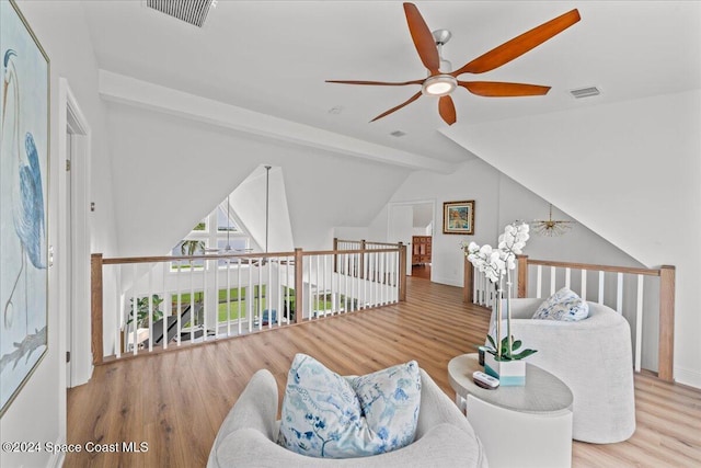 living area with vaulted ceiling with beams, ceiling fan, and hardwood / wood-style flooring