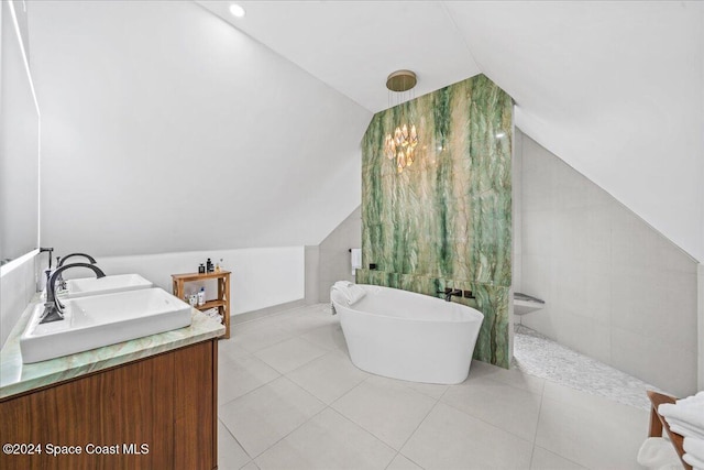 bathroom featuring tile patterned flooring, a bath, a notable chandelier, vaulted ceiling, and vanity