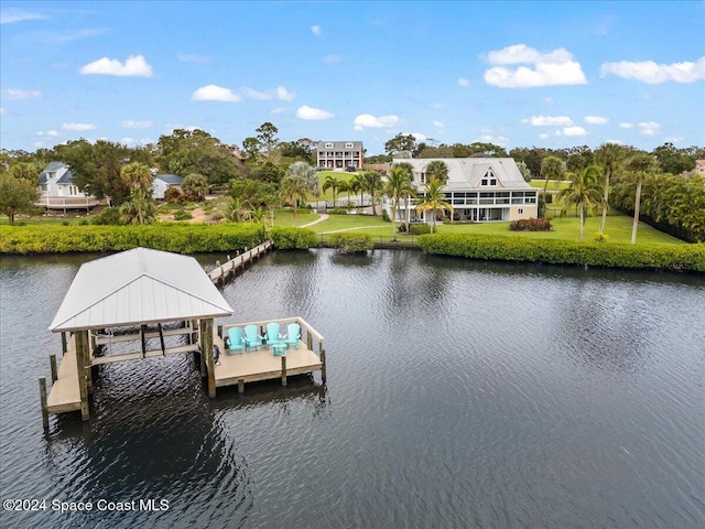 view of dock with a lawn and a water view