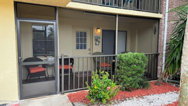 view of exterior entry featuring a balcony