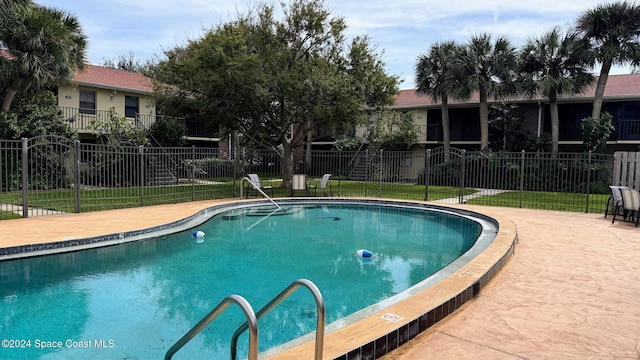 view of pool with a lawn