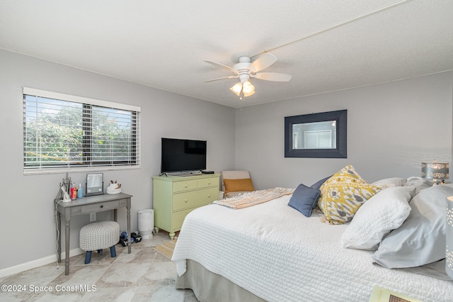 bedroom with ceiling fan and a textured ceiling