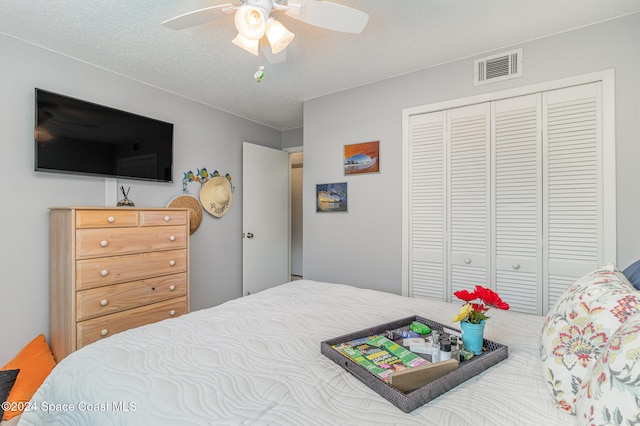 bedroom featuring ceiling fan, a textured ceiling, and a closet