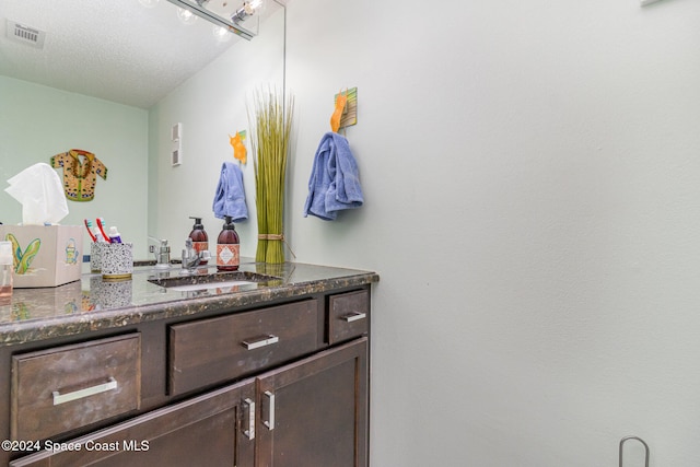 bathroom featuring a textured ceiling and vanity