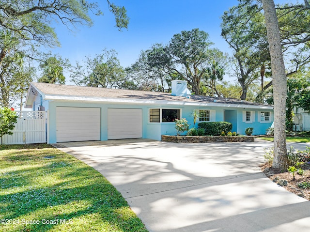 single story home with a front yard and a garage