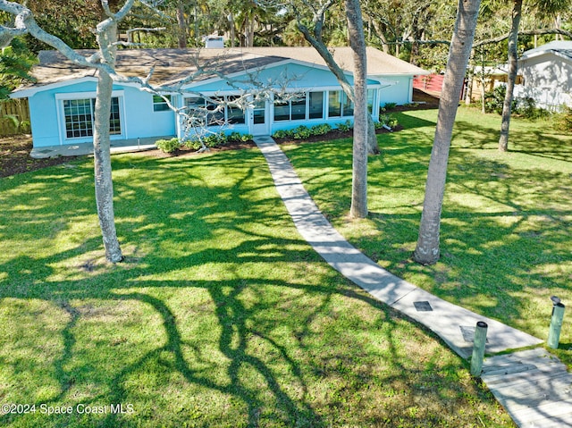 exterior space with a yard, a sunroom, and stucco siding