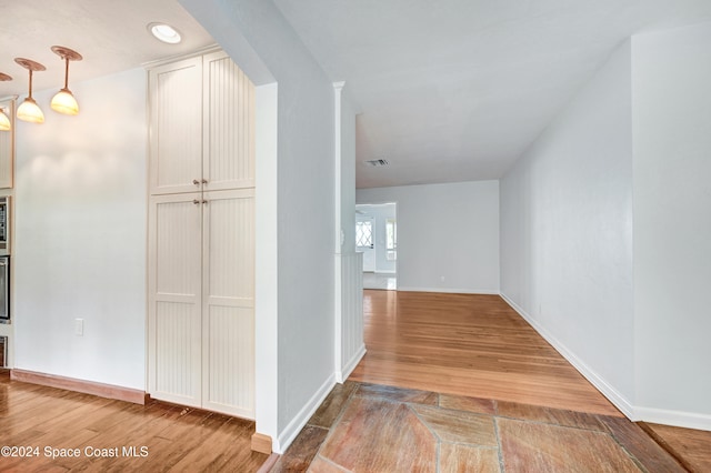 hallway featuring visible vents, baseboards, and light wood-style floors
