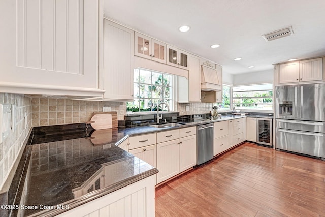 kitchen with visible vents, wine cooler, light wood-type flooring, stainless steel appliances, and a sink