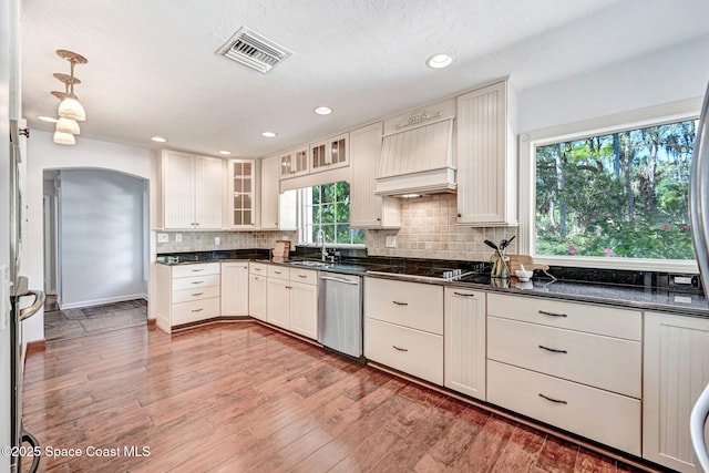 kitchen with visible vents, stainless steel dishwasher, dark countertops, decorative backsplash, and black electric stovetop