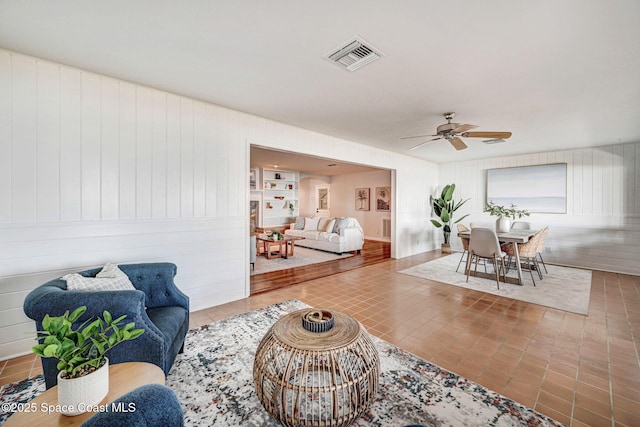living area featuring visible vents and a ceiling fan