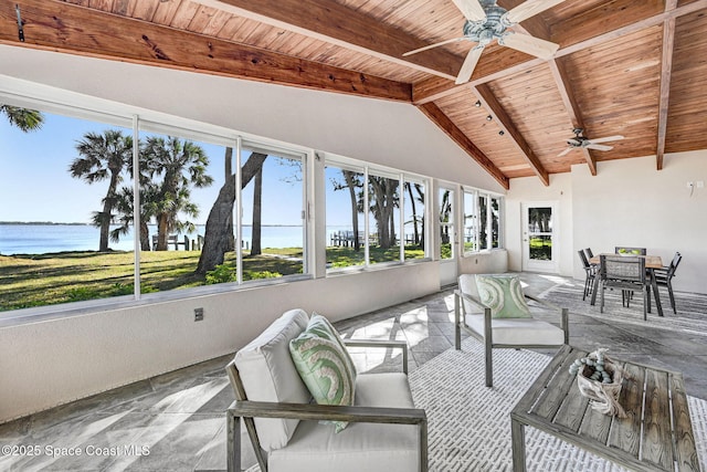 unfurnished sunroom with beamed ceiling, outdoor dining area, a water view, and ceiling fan