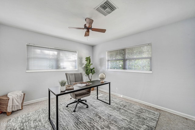 carpeted office space featuring visible vents, baseboards, and ceiling fan